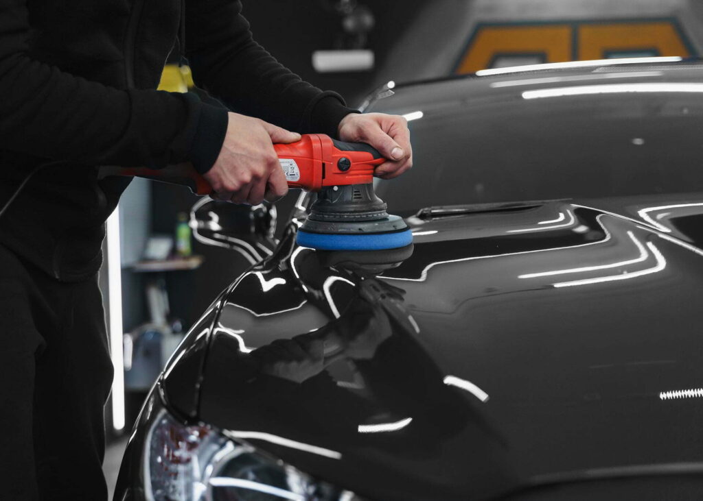 a detailers polishing a black car for mobile detailing process at luxe detailing pro in anaheim ca