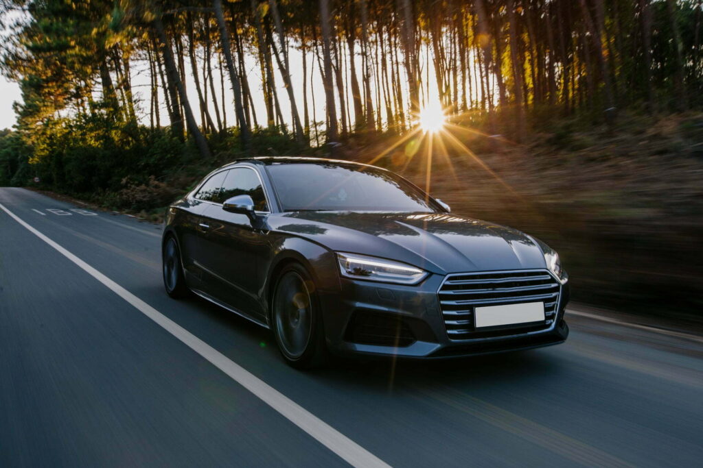 black sport car highway drive sunset after professional exterior detailing process at luxe detailing pro in anaheim california